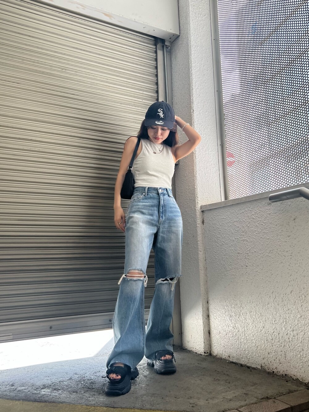 ブラック系のサンダル、ブルー系のデニムパンツ、グレー系のタンクトップを着用したレディースの夏コーディネートの2枚目の写真