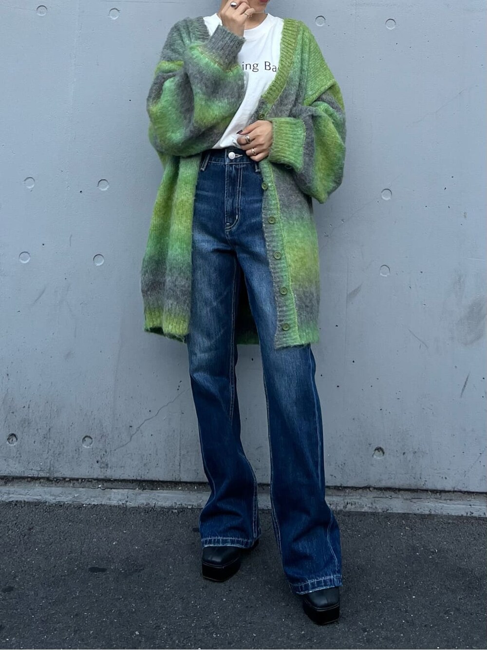 ブラック系のブーツ、ホワイト系のTシャツ/カットソー、ブルー系のデニムパンツを着用したレディースの秋コーディネートの2枚目の写真