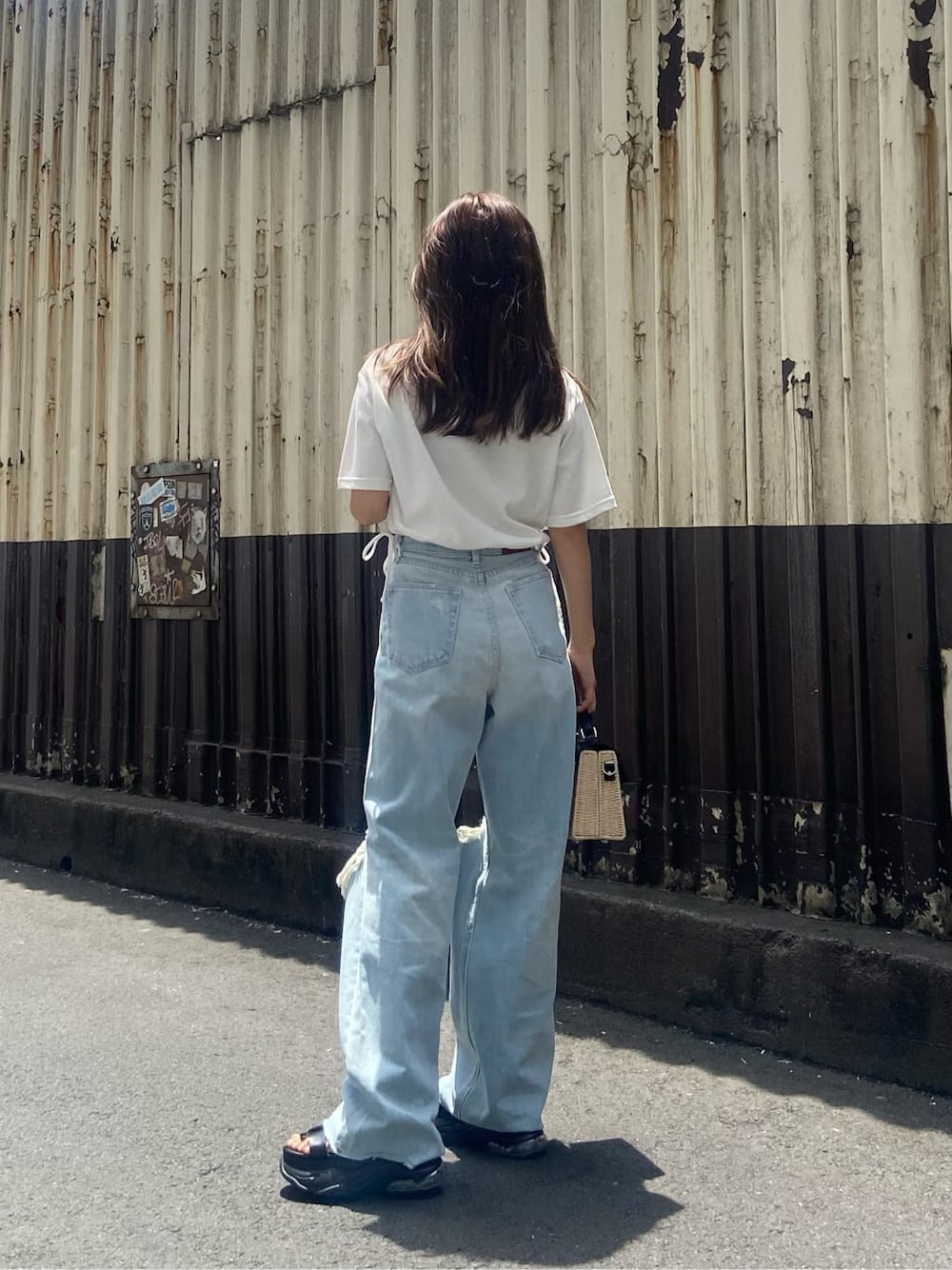 ブラック系のサンダル、ホワイト系のTシャツ/カットソー、ブルー系のデニムパンツを着用したレディースの夏コーディネートの4枚目の写真