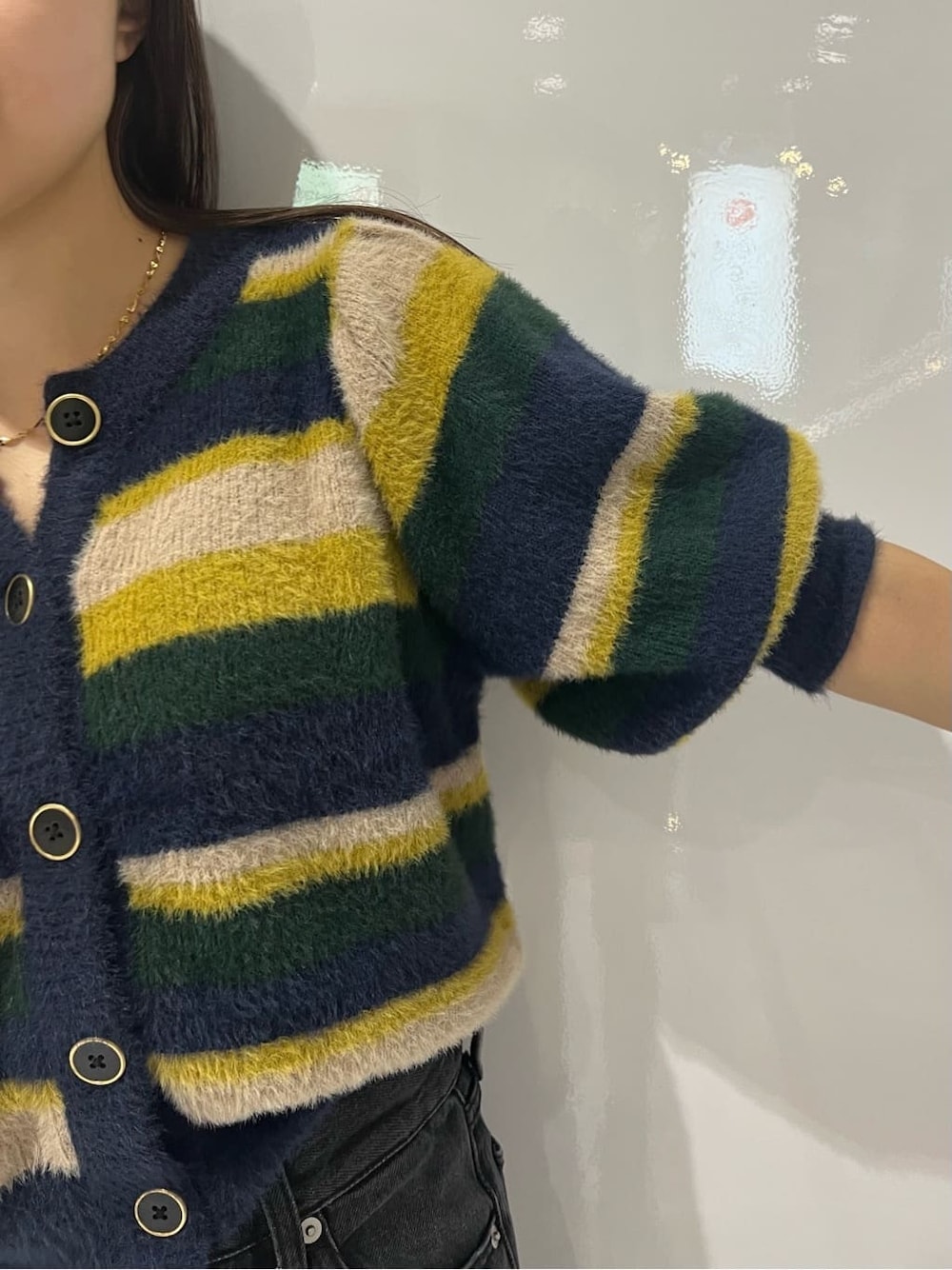 ブラック系のブーツ、ブラック系のデニムパンツ、ブルー系のニット/セーターを着用したレディースの秋コーディネートの6枚目の写真