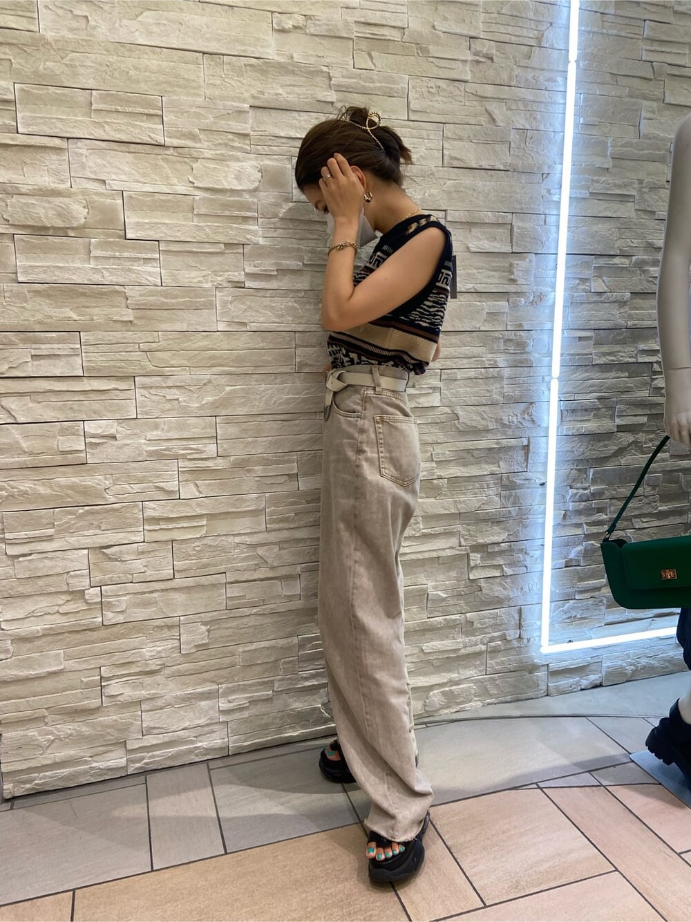 ブラック系のサンダル、ブラック系のタンクトップ、ベージュ系のデニムパンツを着用したレディースの夏コーディネートの2枚目の写真