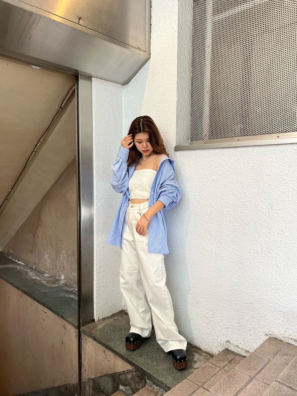 ホワイト系のデニムパンツ、ホワイト系のニット/セーター、ブルー系のシャツ/ブラウスを着用したレディースの春コーディネートの3枚目の写真