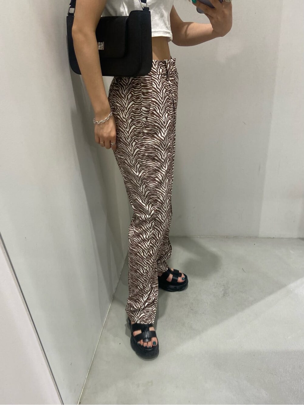 ホワイト系のTシャツ/カットソー、ブラック系のサンダル、その他のその他パンツを着用したレディースの春コーディネートの3枚目の写真