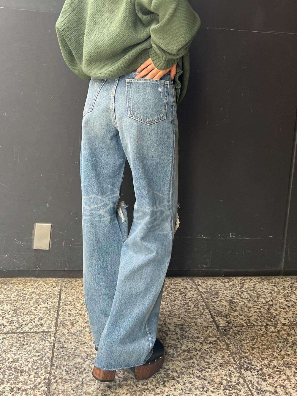 ブルー系のデニムパンツ、ブラック系のサンダル、グリーン系のニット/セーターを着用したレディースの夏コーディネートの5枚目の写真