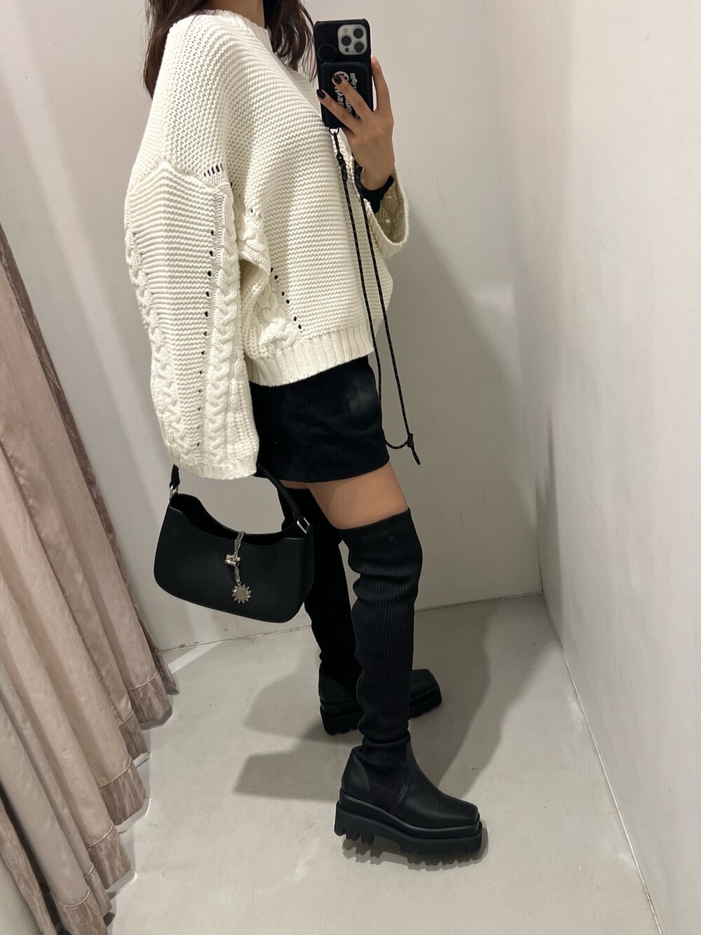 ホワイト系のニット/セーター、ブラック系のその他パンツ、ブラック系のブーツを着用したレディースの秋コーディネートの4枚目の写真