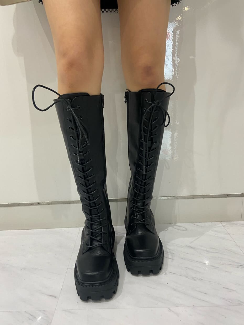 ブラック系のブーツ、ホワイト系のショルダーバッグ、ブラック系のワンピースを着用したレディースの夏コーディネートの9枚目の写真