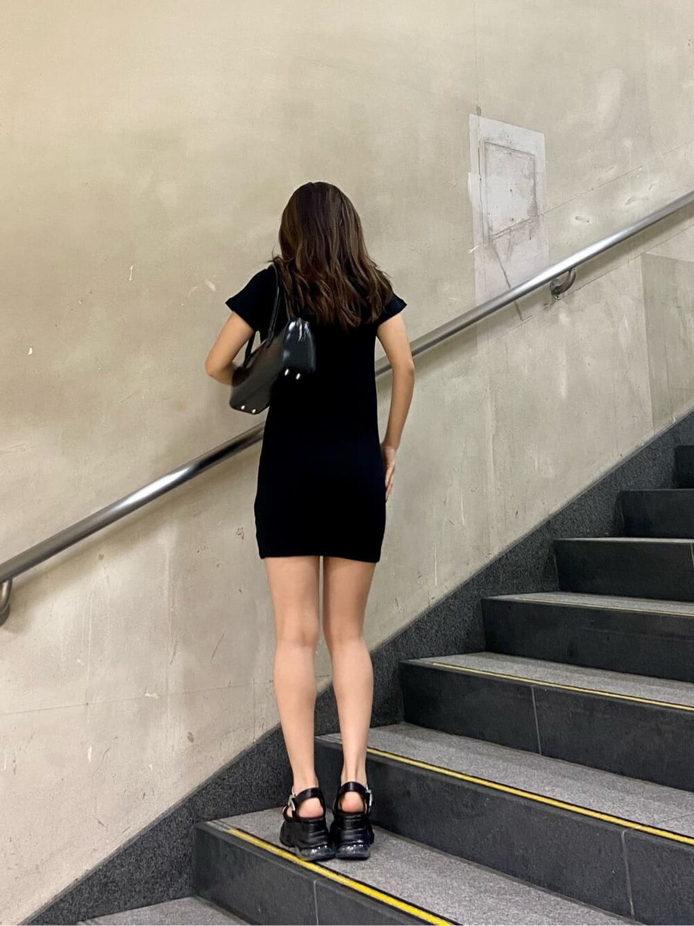 ブラック系のボストンバッグ、ブラック系のワンピース、ブラック系のサンダルを着用したレディースの春コーディネートの6枚目の写真