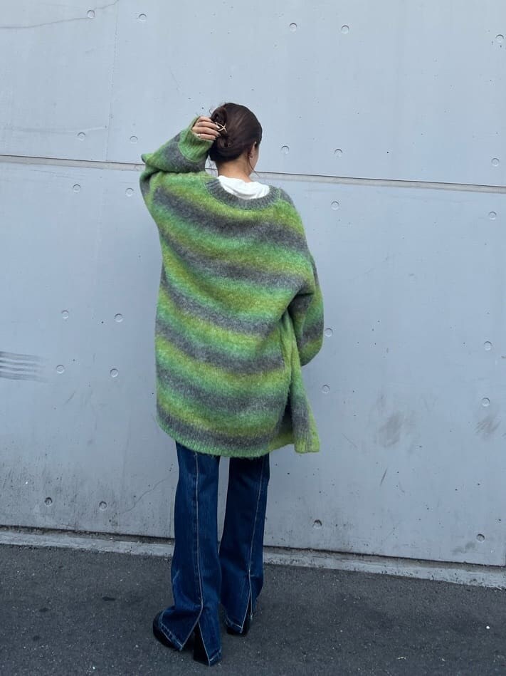 ブラック系のブーツ、ホワイト系のTシャツ/カットソー、ブルー系のデニムパンツを着用したレディースの秋コーディネートの4枚目の写真