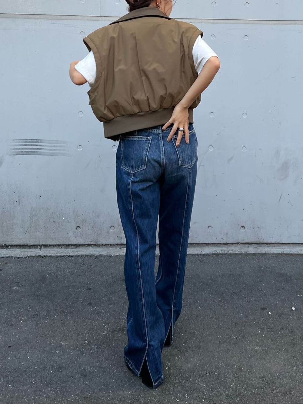 ブラック系のブーツ、ホワイト系のTシャツ/カットソー、ベージュ系のMA-1を着用したレディースの秋コーディネートの3枚目の写真