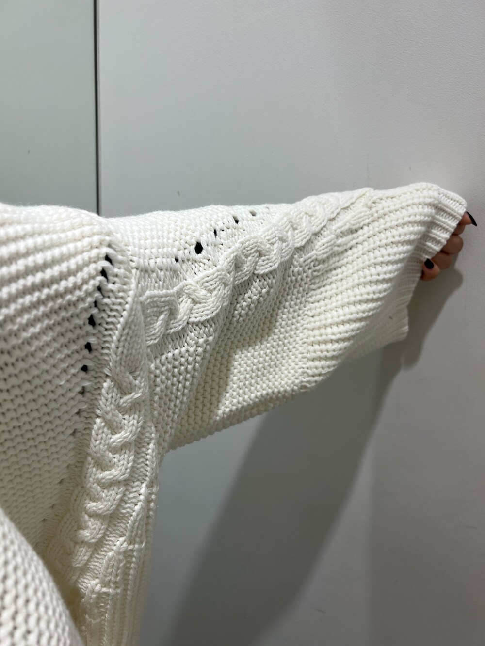 ホワイト系のニット/セーター、ブラック系のその他パンツ、ブラック系のブーツを着用したレディースの秋コーディネートの6枚目の写真