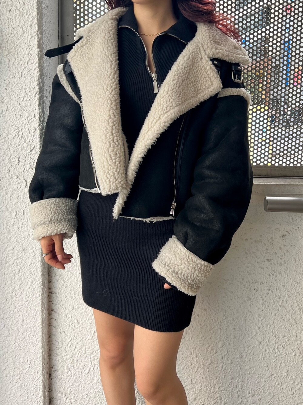 ブラック系のブーツ、ブラック系のムートンコート、ブラック系のワンピースを着用したレディースの秋コーディネートの2枚目の写真