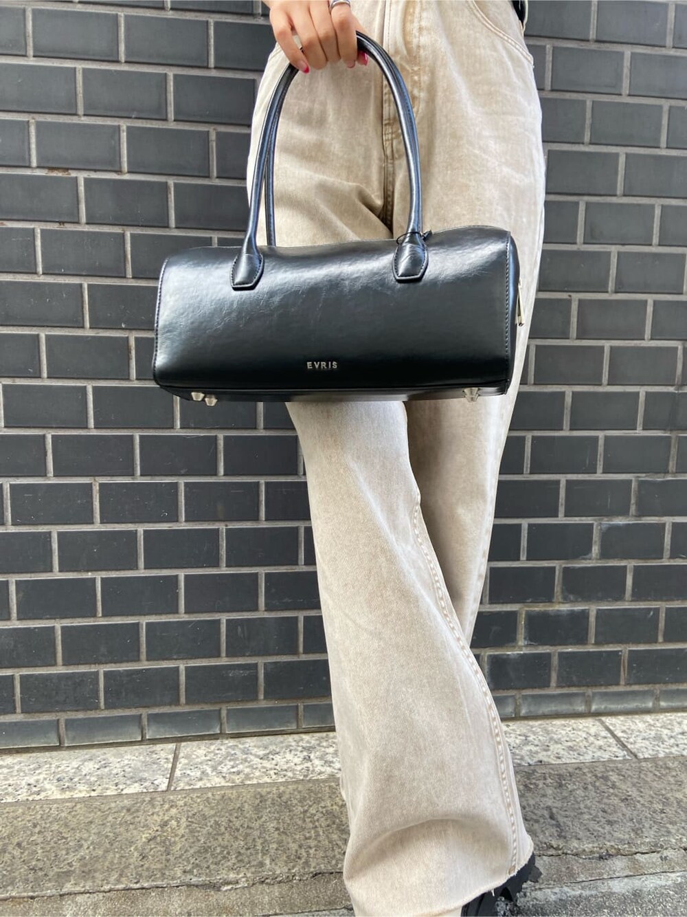 ブラック系のボストンバッグ、ベージュ系のTシャツ/カットソー、ベージュ系のデニムパンツを着用したレディースの春コーディネートの7枚目の写真