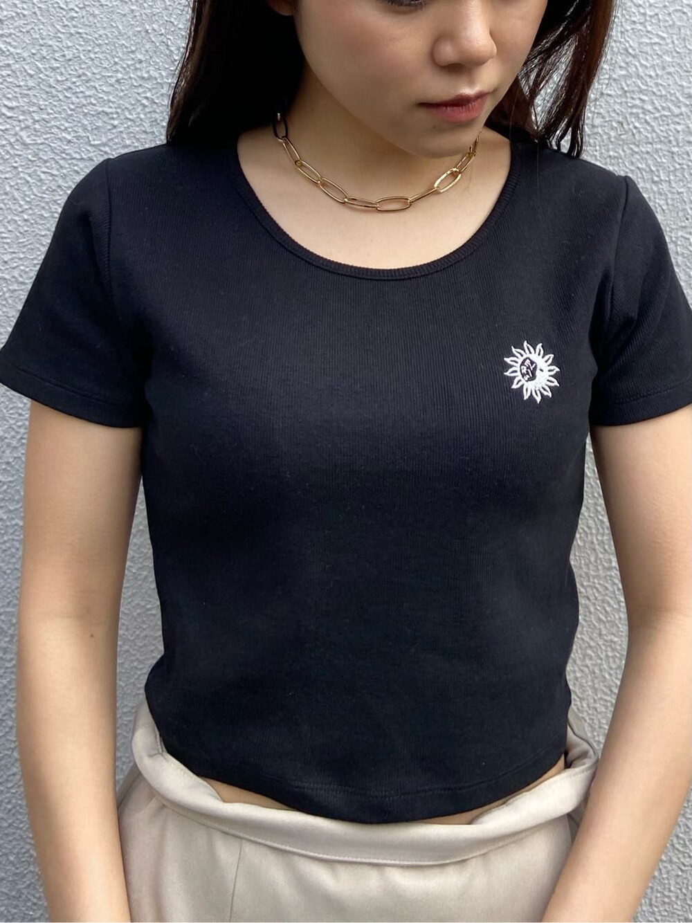 ブラック系のショルダーバッグ、ブラック系のTシャツ/カットソー、ベージュ系のスカートを着用したレディースの春コーディネートの5枚目の写真