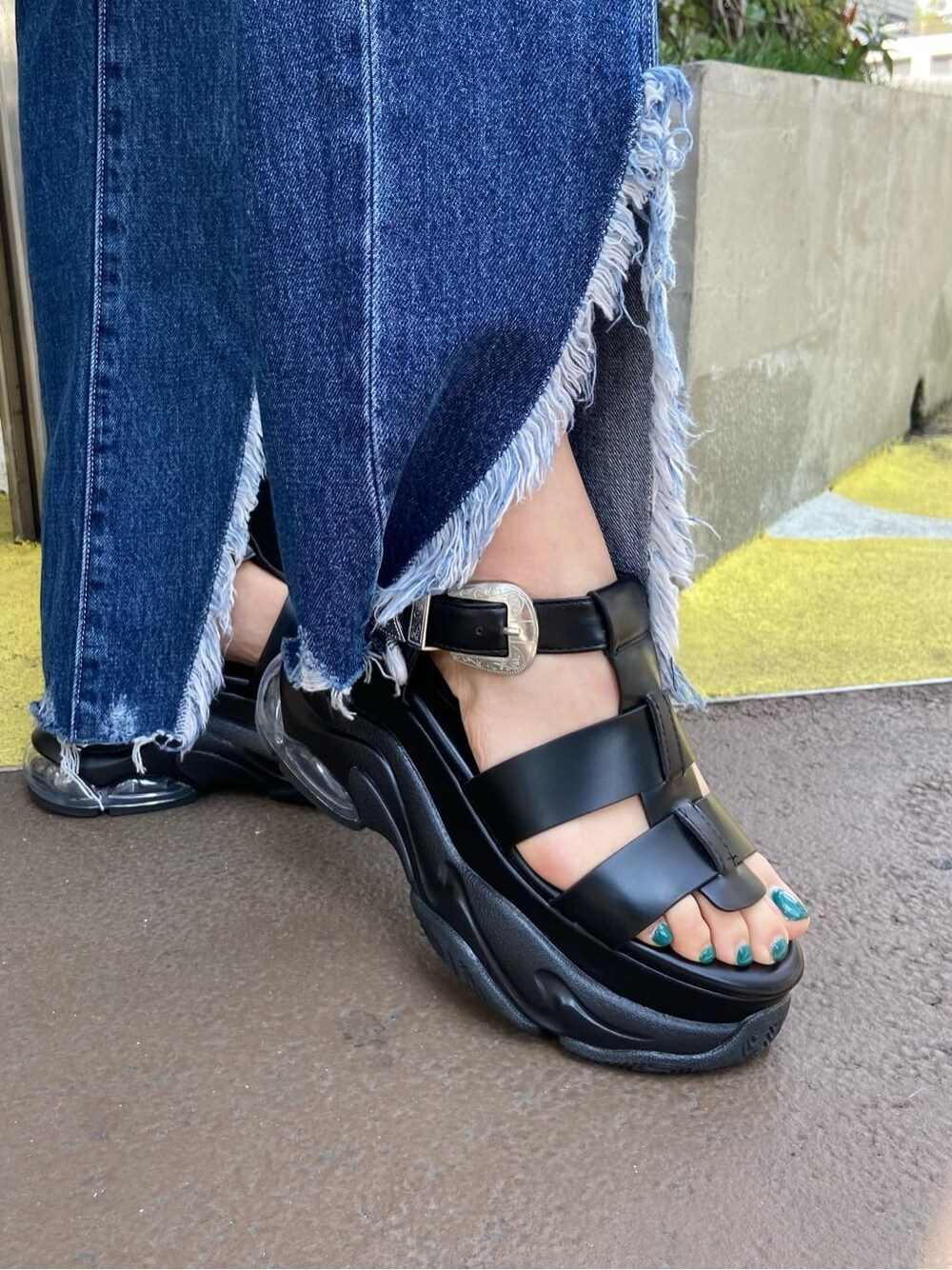 ブラック系のショルダーバッグ、ホワイト系のTシャツ/カットソー、ブルー系のデニムパンツを着用したレディースの春コーディネートの8枚目の写真