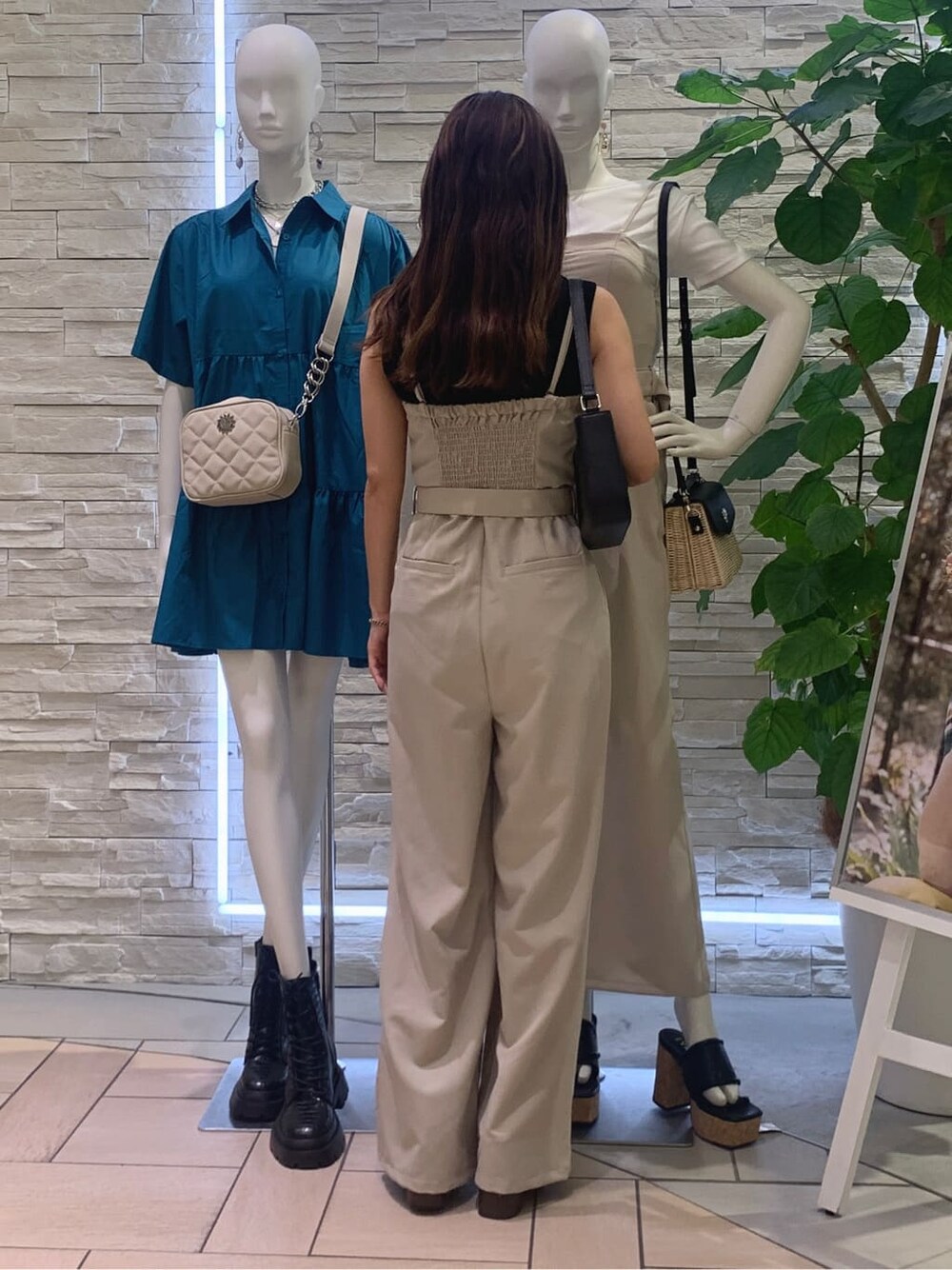 ブラック系のタンクトップ、ホワイト系のサロペット/オーバーオール、ブラック系のショルダーバッグを着用したレディースの夏コーディネートの3枚目の写真