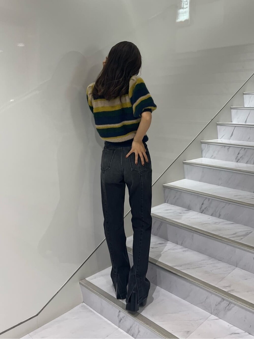 ブラック系のブーツ、ブラック系のデニムパンツ、ブルー系のニット/セーターを着用したレディースの秋コーディネートの3枚目の写真