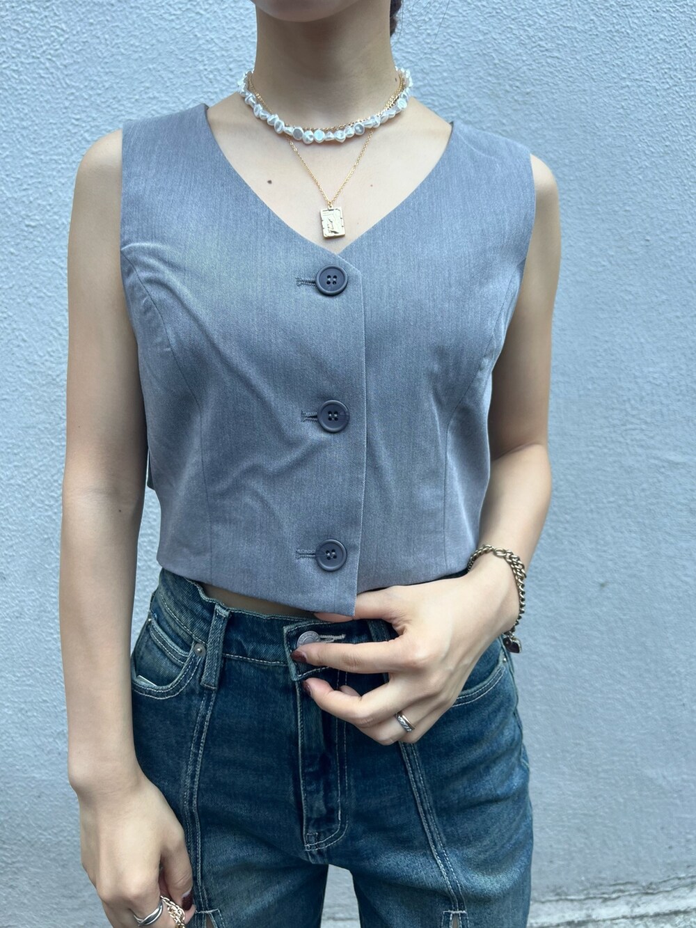 ブルー系のデニムパンツ、グレー系のシャツ/ブラウス、ブラック系のショルダーバッグを着用したレディースの夏コーディネートの7枚目の写真