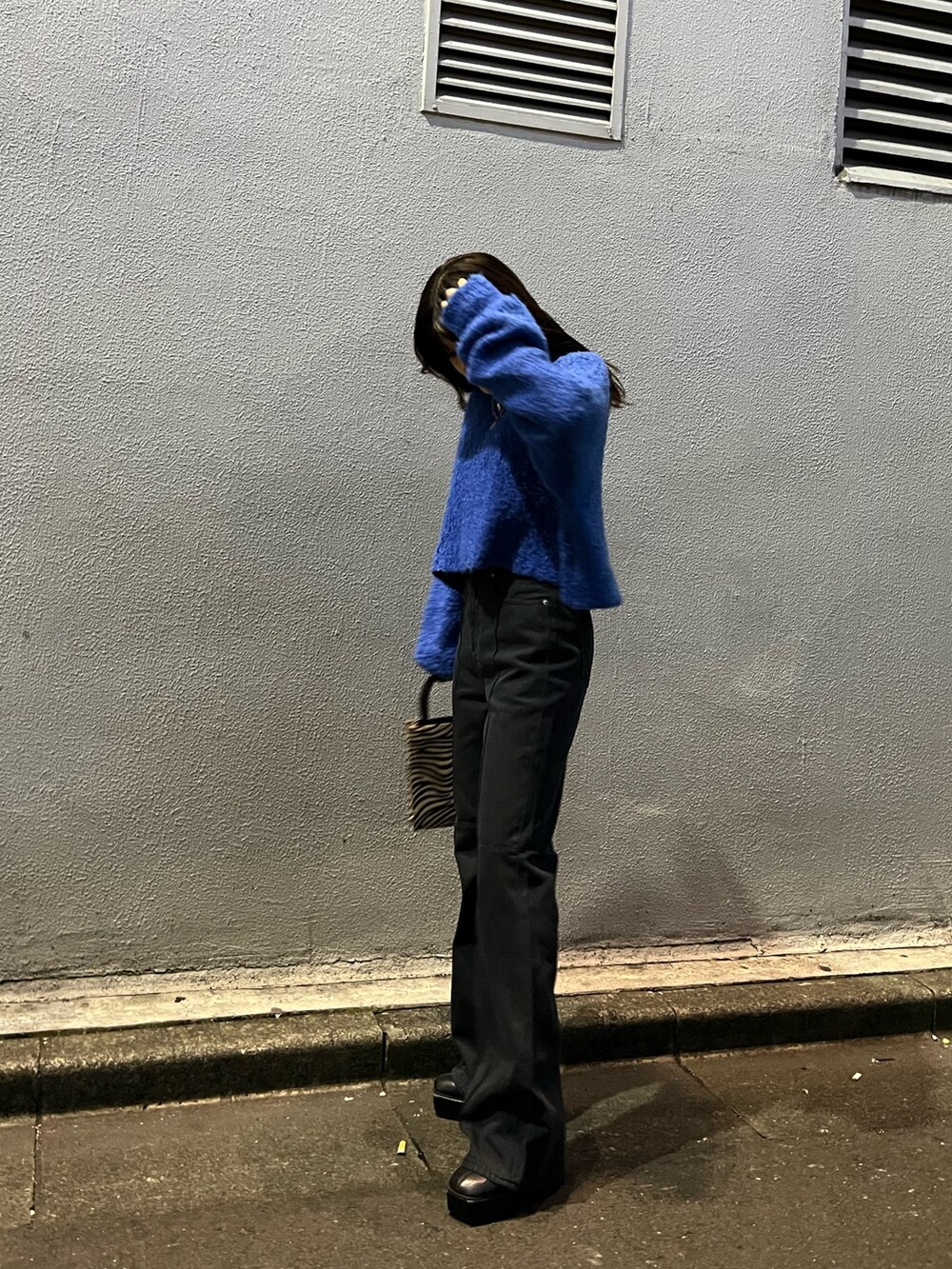 ブルー系のニット/セーター、その他のショルダーバッグ、ブラック系のデニムパンツを着用したレディースの冬コーディネートの3枚目の写真