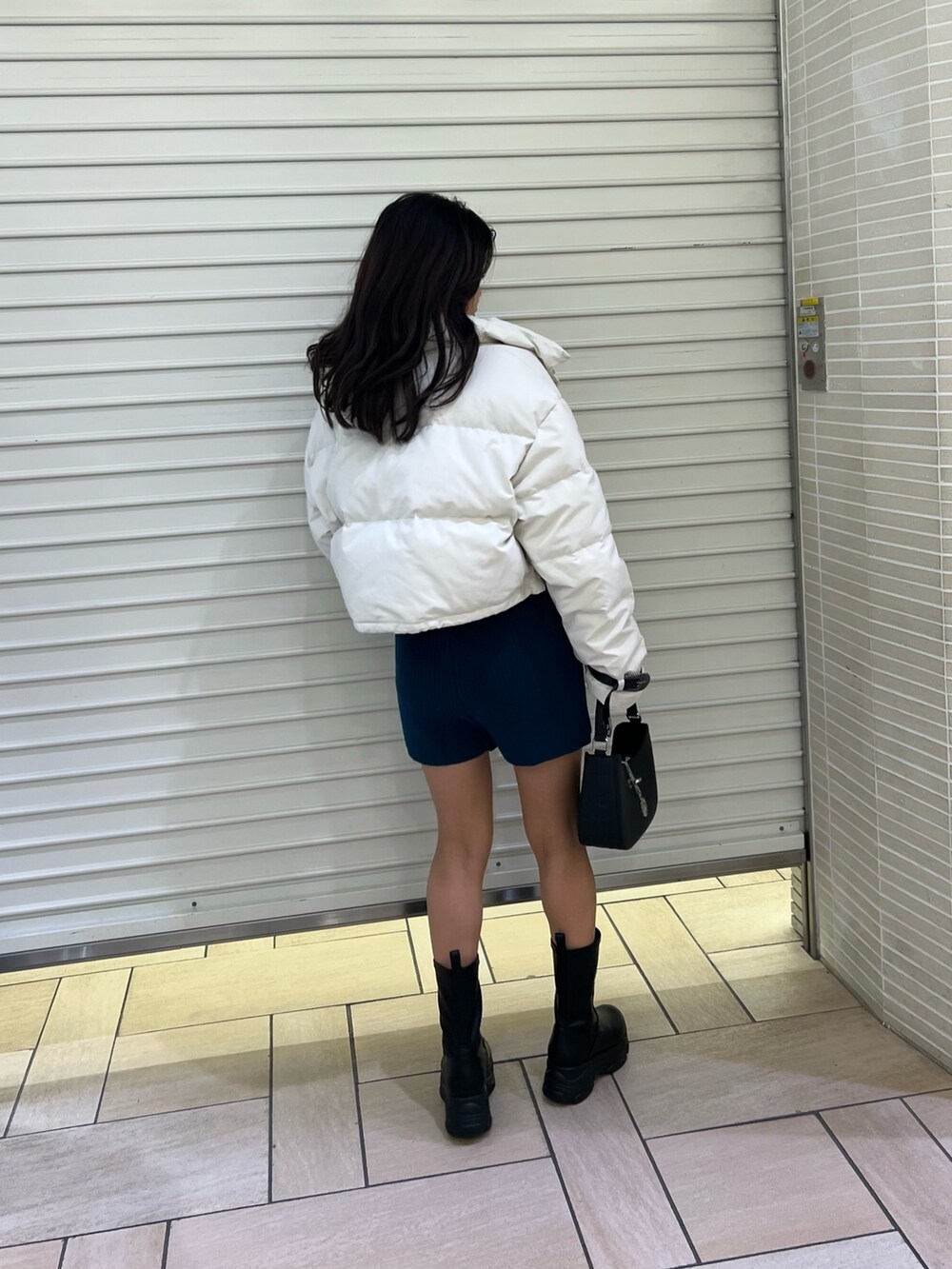 ブルー系のその他パンツ、ホワイト系のTシャツ/カットソー、ホワイト系のダウンジャケット/コートを着用したレディースの秋コーディネートの3枚目の写真