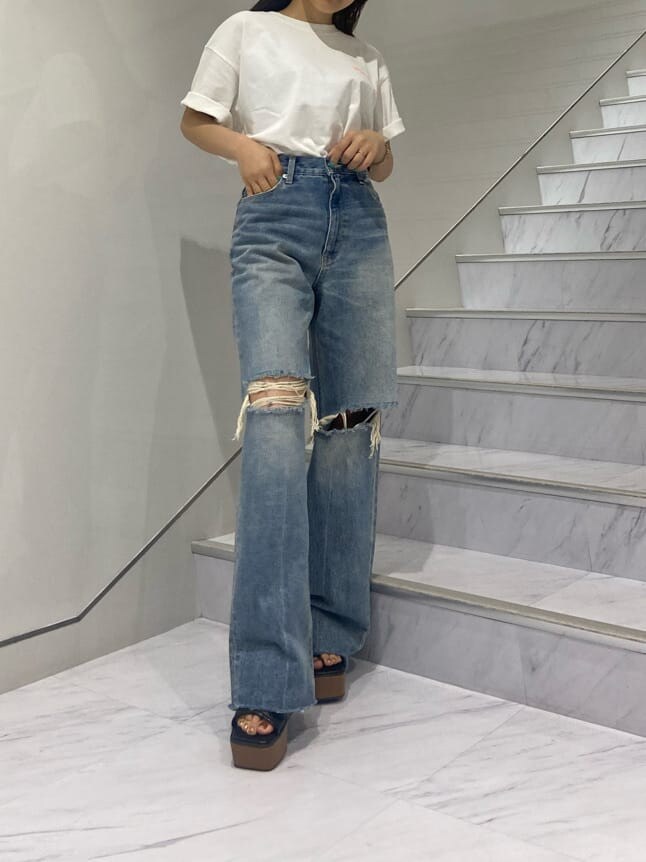 ブラック系のショルダーバッグ、ブラック系のサンダル、ブルー系のデニムパンツを着用したレディースの夏コーディネートの2枚目の写真