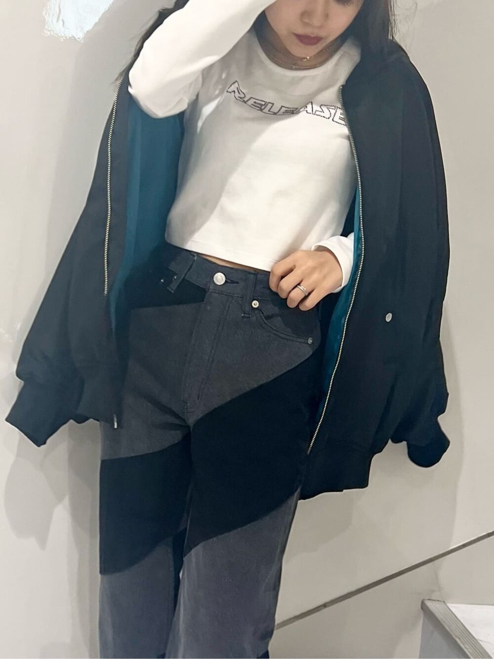 ブラック系のMA-1、ホワイト系のTシャツ/カットソー、ブラック系のデニムパンツを着用したレディースの秋コーディネートの7枚目の写真