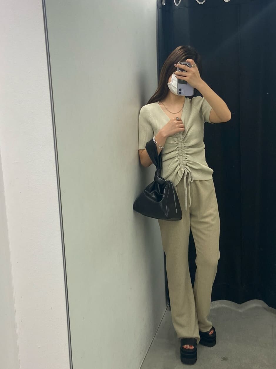 ホワイト系のニット/セーター、ブラック系のサンダル、ブラック系のハンドバッグを着用したレディースの夏コーディネートの5枚目の写真