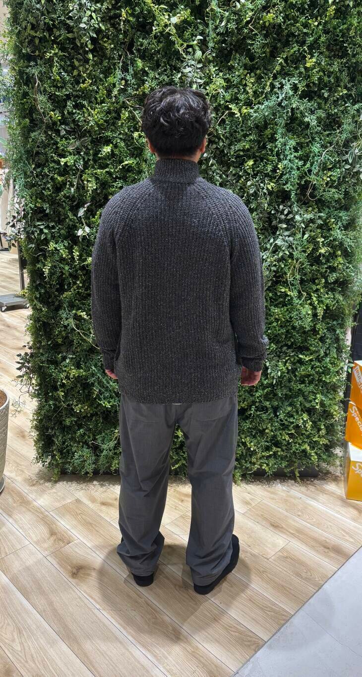 グレー系のニット/セーター、ブラック系のブーツを着用したメンズの冬コーディネートの3枚目の写真