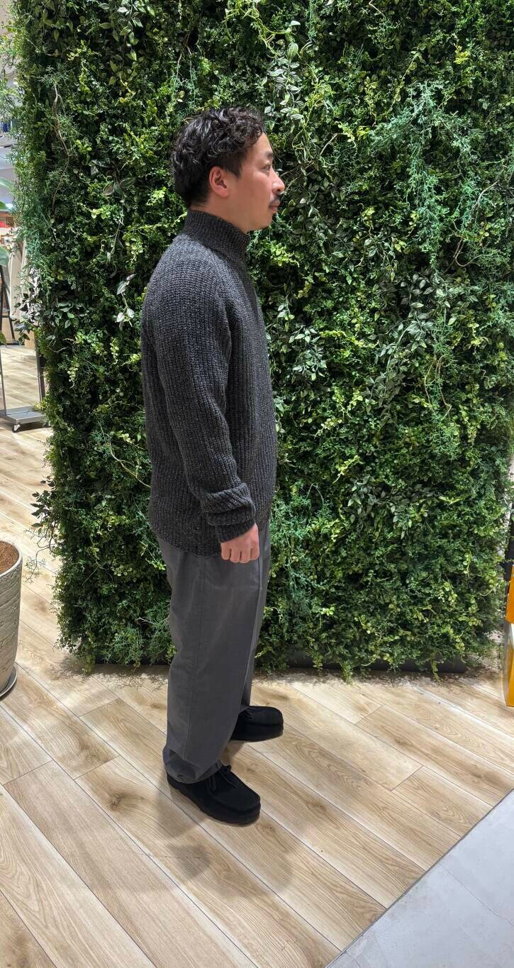 グレー系のニット/セーター、ブラック系のブーツを着用したメンズの冬コーディネートの2枚目の写真