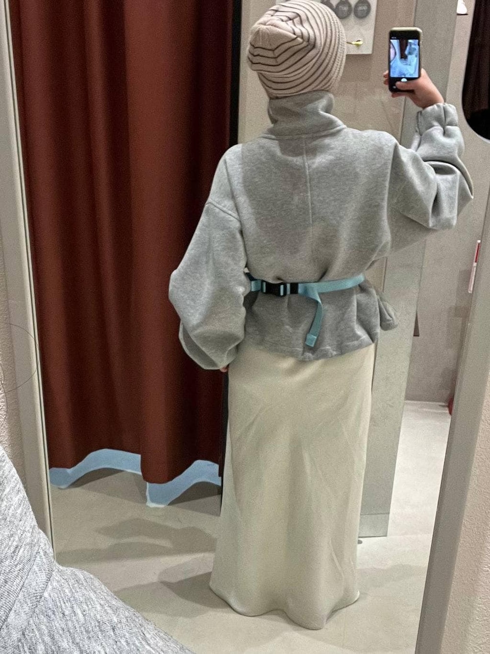 ホワイト系のスカート、ブルー系のボディバッグ/ウエストポーチ、ブラック系のローファーを着用したレディースの冬コーディネートの3枚目の写真