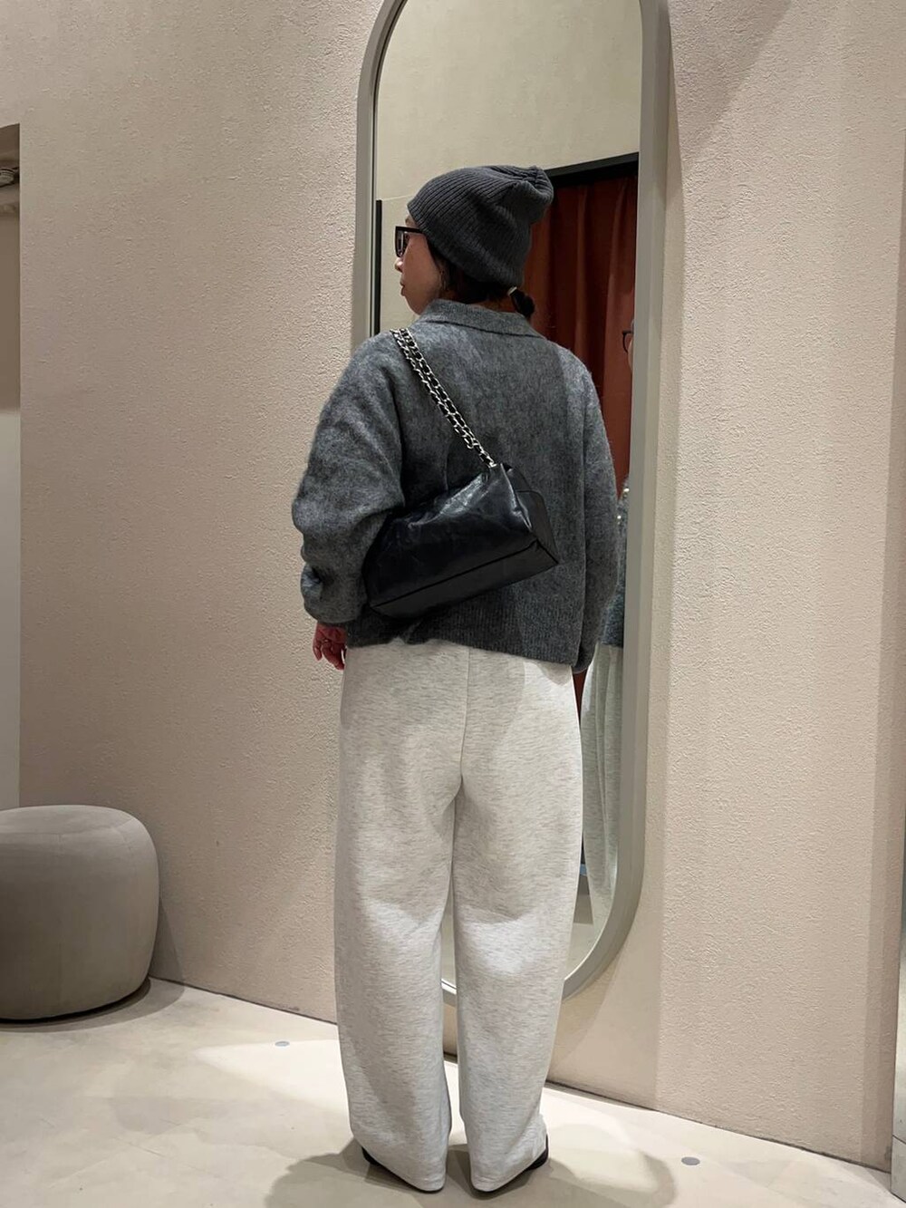 ブラック系のステンカラーコート、グレー系のスウェットパンツ、グレー系のニット/セーターを着用したレディースの冬コーディネートの4枚目の写真