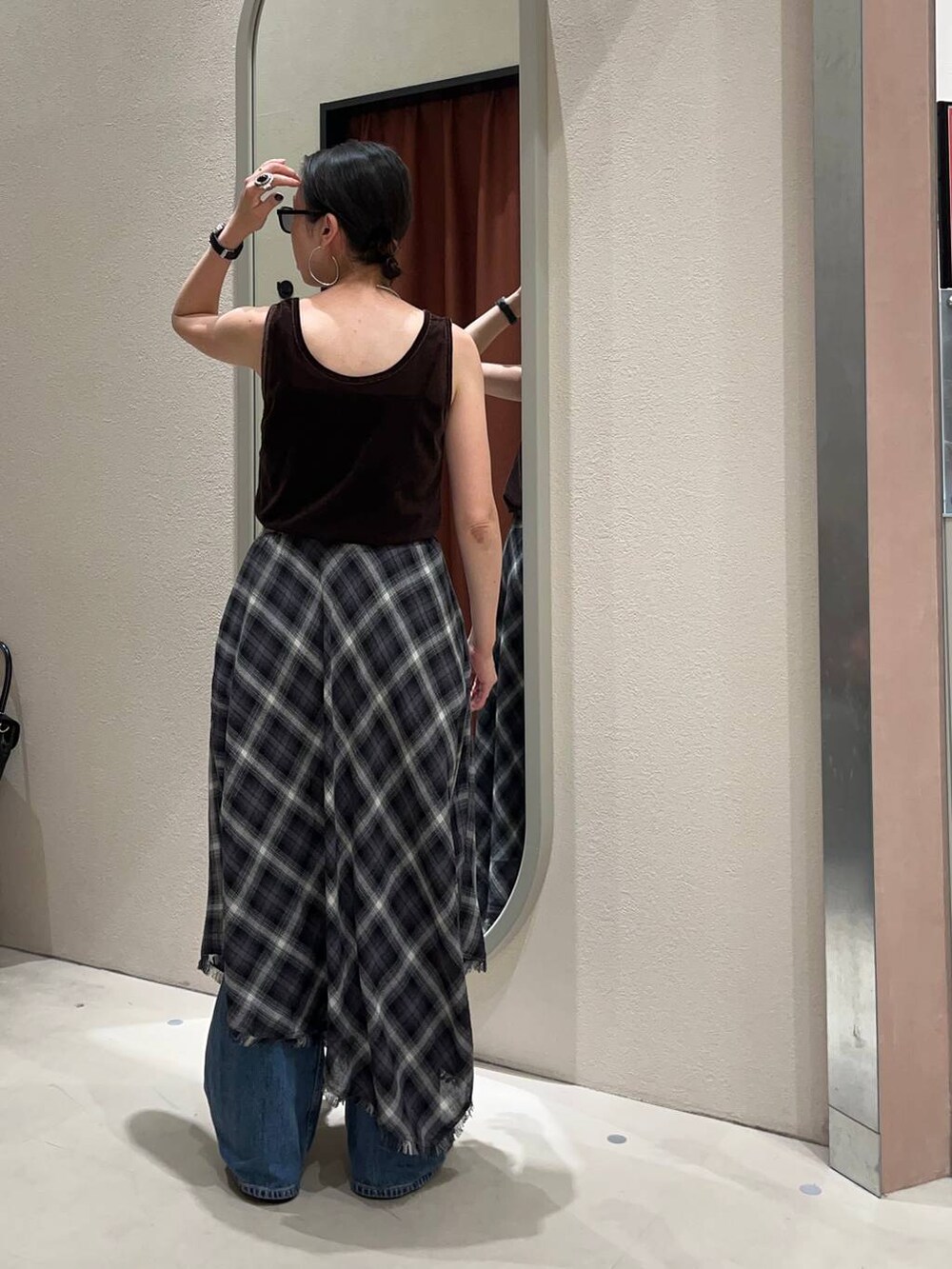 ブラック系のサンダル、ブルー系のデニムパンツ、グレー系のスカートを着用したレディースの夏コーディネートの3枚目の写真