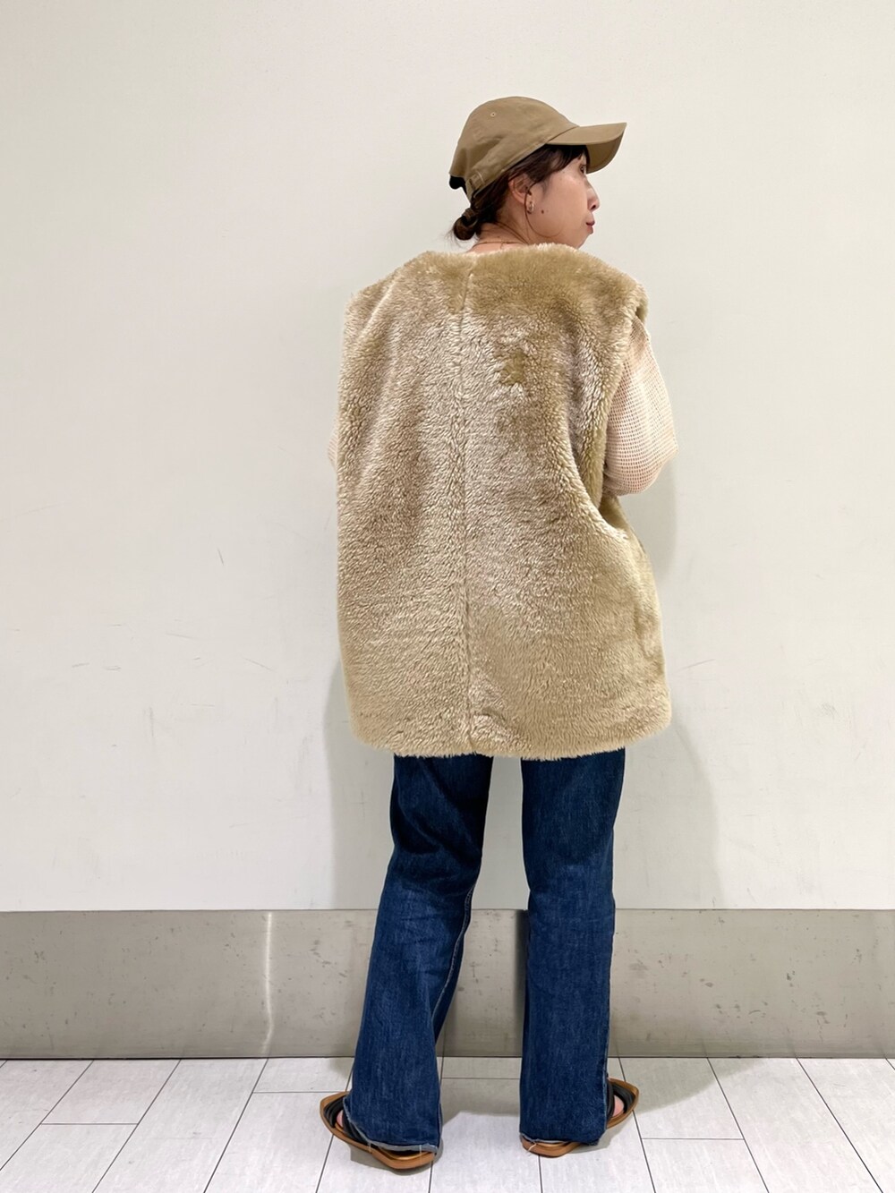 ベージュ系のジャケット/アウター、ブルー系のデニムパンツ、ブラック系のサンダルを着用したレディースの秋コーディネートの2枚目の写真