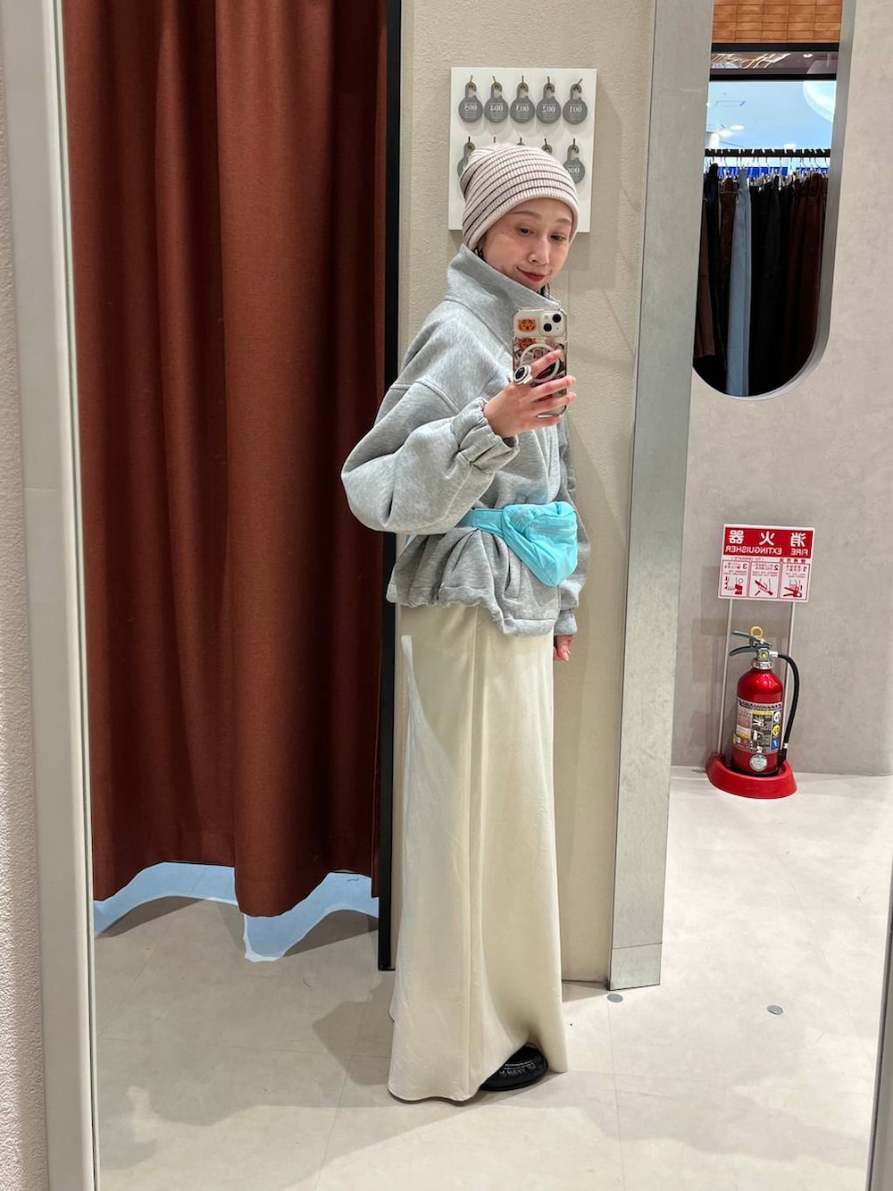 ホワイト系のスカート、ブルー系のボディバッグ/ウエストポーチ、ブラック系のローファーを着用したレディースの冬コーディネートの2枚目の写真