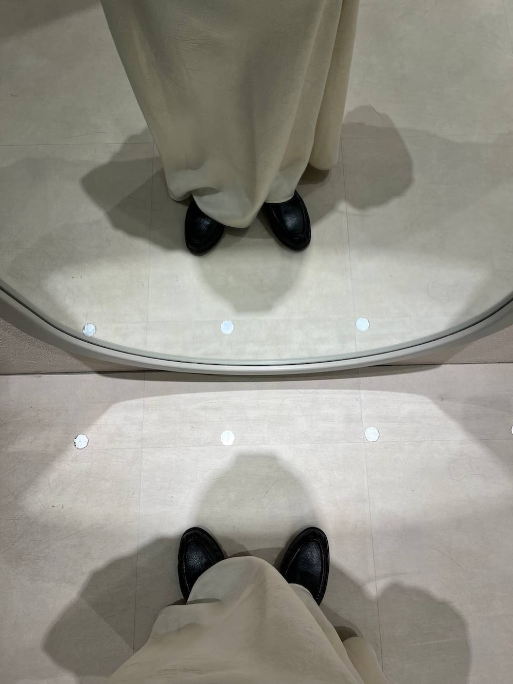 ホワイト系のスカート、ブルー系のボディバッグ/ウエストポーチ、ブラック系のローファーを着用したレディースの冬コーディネートの4枚目の写真