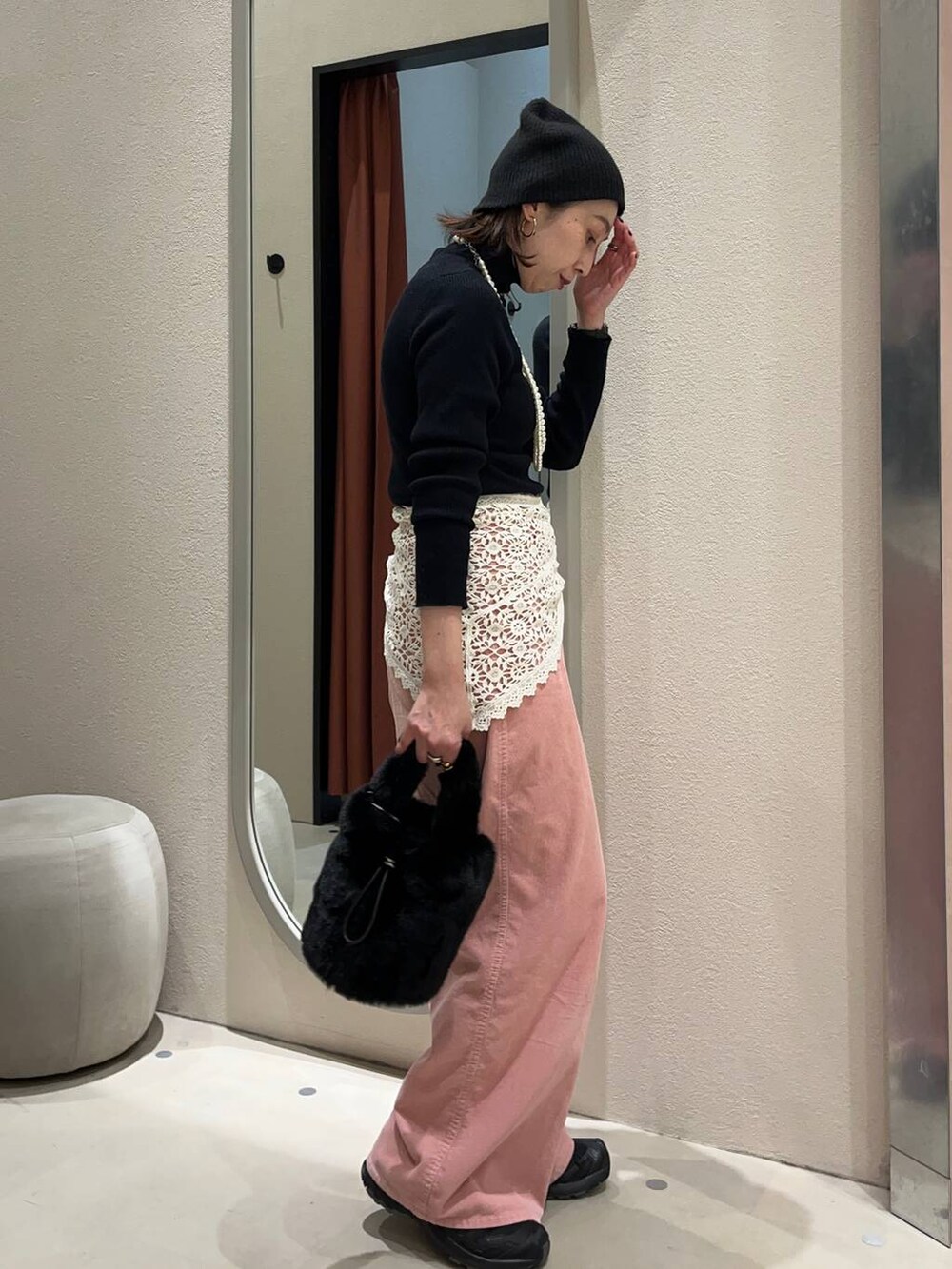 ブラック系のニット/セーター、ブラック系のショルダーバッグ、ピンク系のその他パンツを着用したレディースの冬コーディネートの2枚目の写真