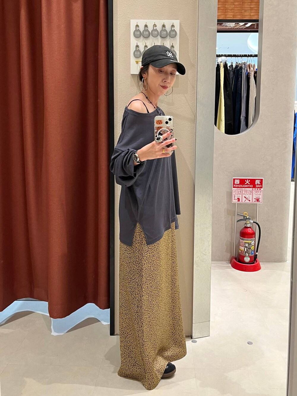 その他のスカート、グレー系のTシャツ/カットソー、ブラック系のキャップを着用したレディースの夏コーディネートの2枚目の写真