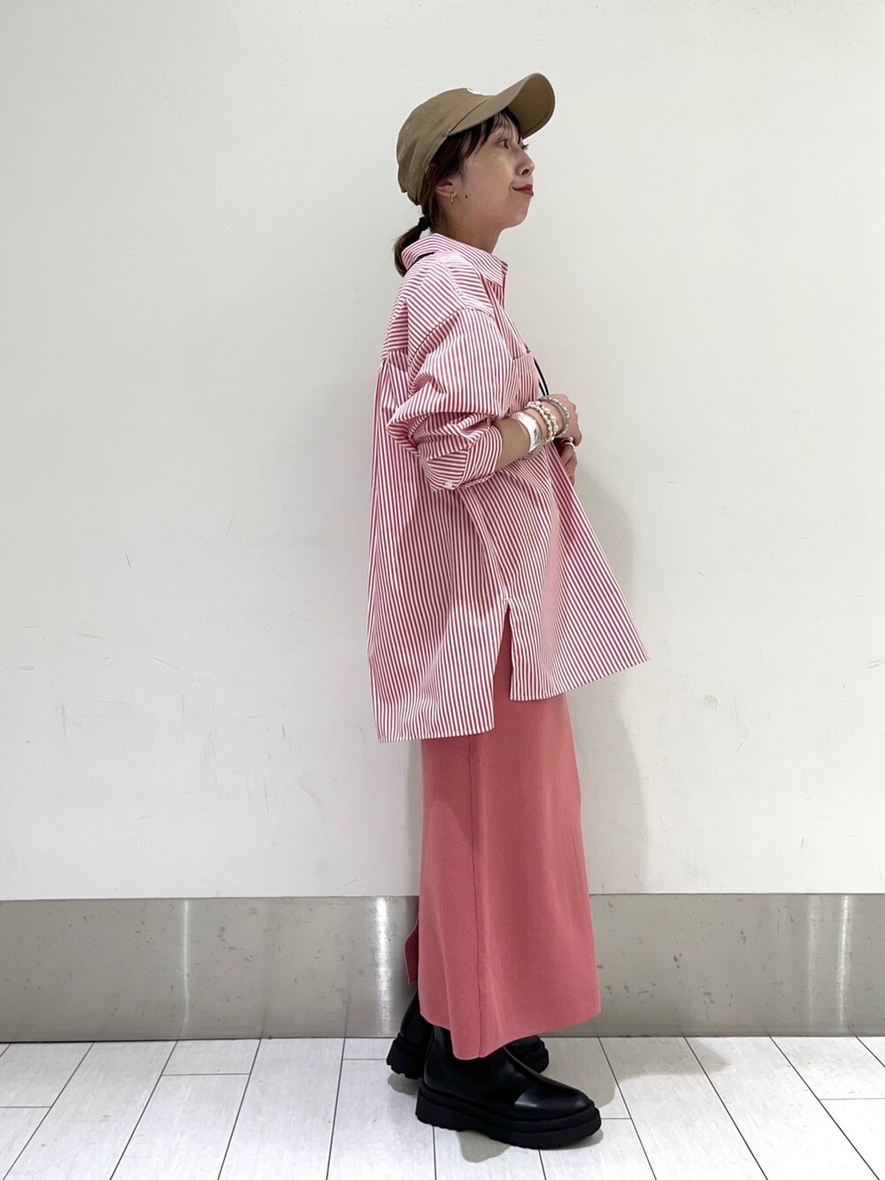 ブラック系のショルダーバッグ、その他のシューズ、ピンク系のスカートを着用したレディースの秋コーディネートの2枚目の写真