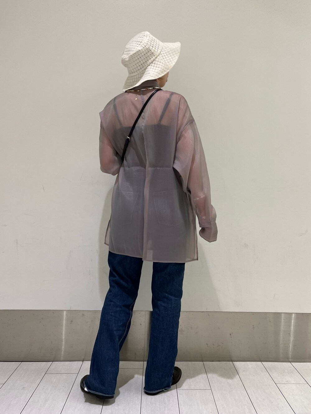 ブルー系のデニムパンツ、ブラック系のローファー、パープル系のシャツ/ブラウスを着用したレディースの春コーディネートの2枚目の写真