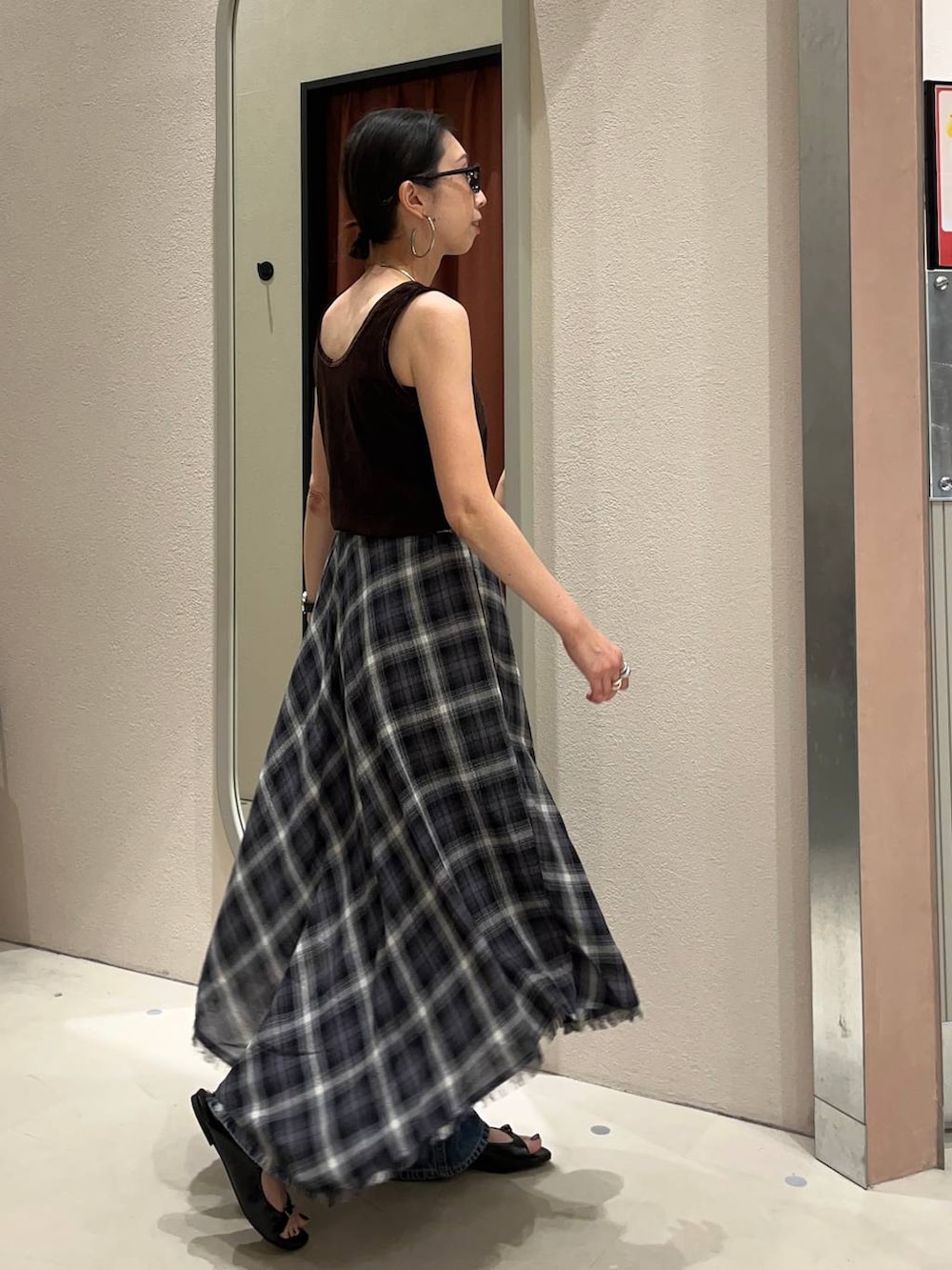 ブラック系のサンダル、ブルー系のデニムパンツ、グレー系のスカートを着用したレディースの夏コーディネートの2枚目の写真