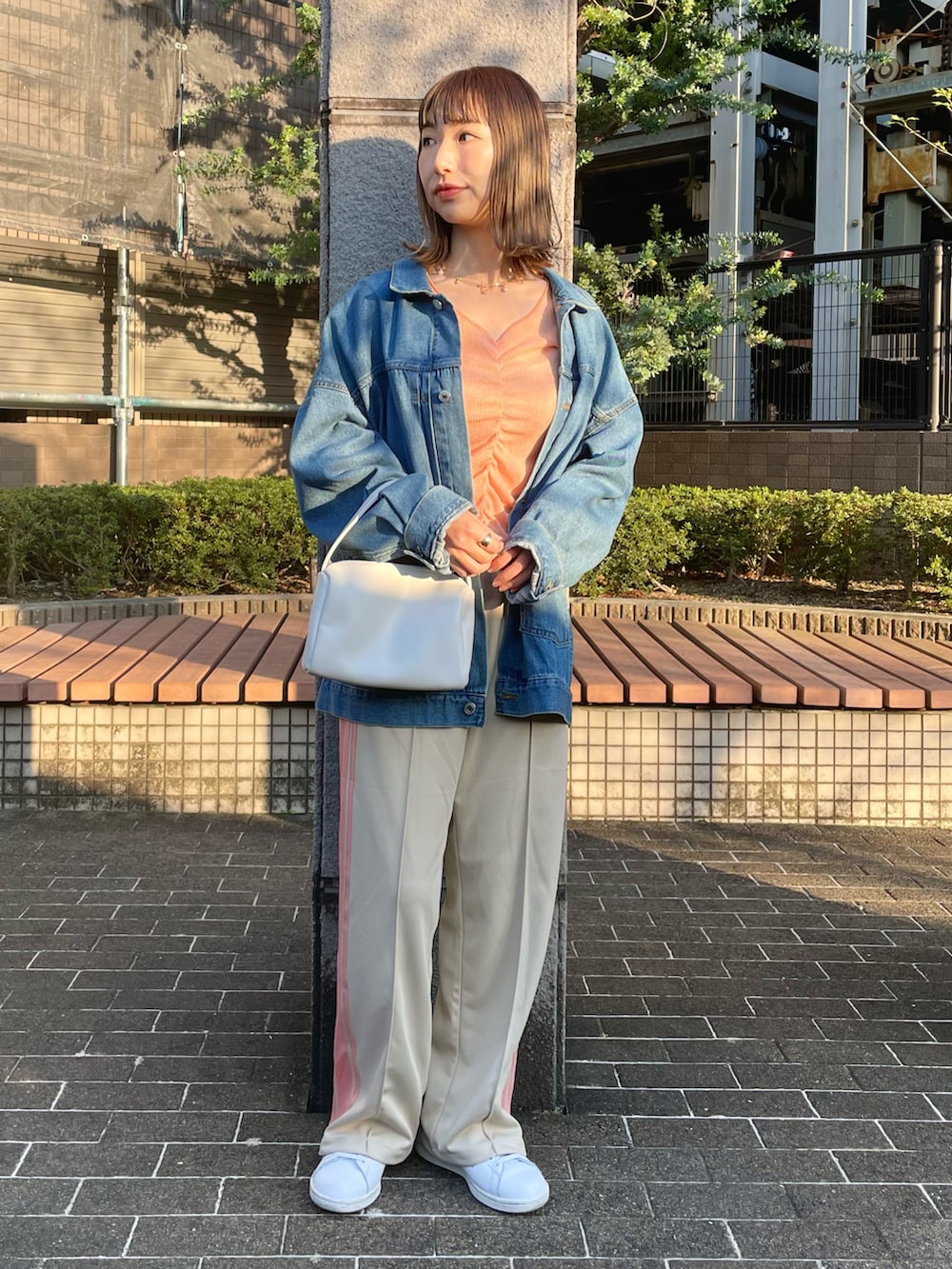 オレンジ系のTシャツ/カットソー、ベージュ系のその他パンツ、ブルー系のデニムジャケットを着用したレディースの春コーディネートの2枚目の写真