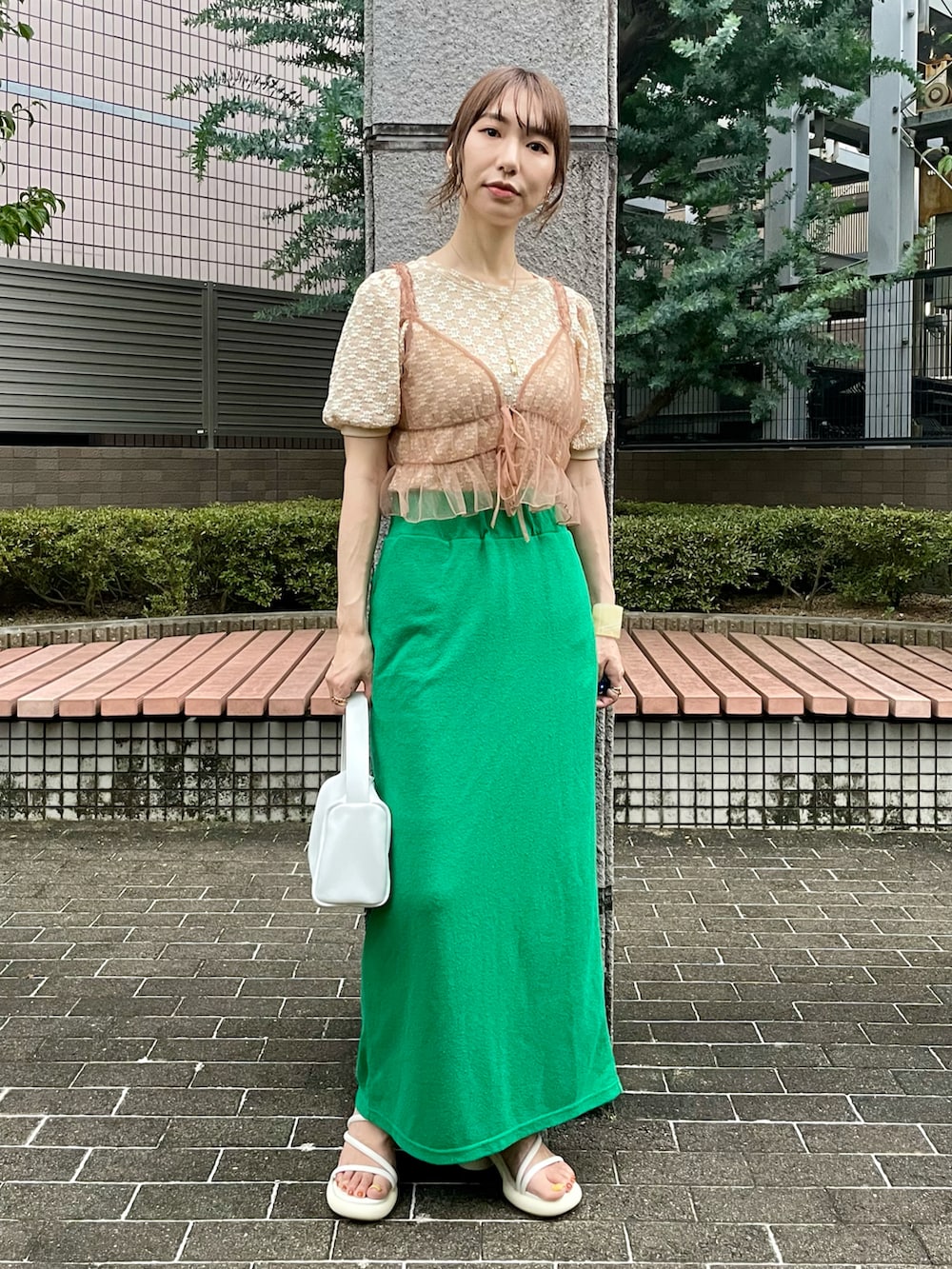 ベージュ系のTシャツ/カットソー、ベージュ系のキャミソール、グリーン系のスカートを着用したレディースの夏コーディネートの2枚目の写真