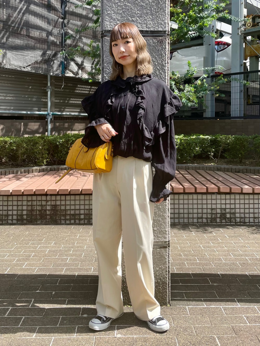 ブラック系のシャツ/ブラウス、ホワイト系のパンツ、ブラック系のスニーカーを着用したレディースの春コーディネートの2枚目の写真