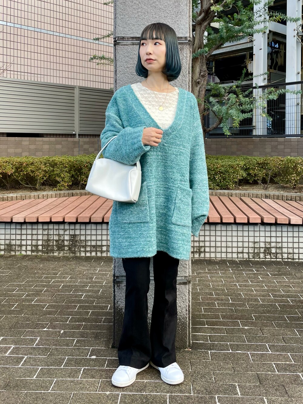 ブルー系のニット/セーター、ホワイト系のTシャツ/カットソー、ブラック系のその他パンツを着用したレディースの冬コーディネートの2枚目の写真