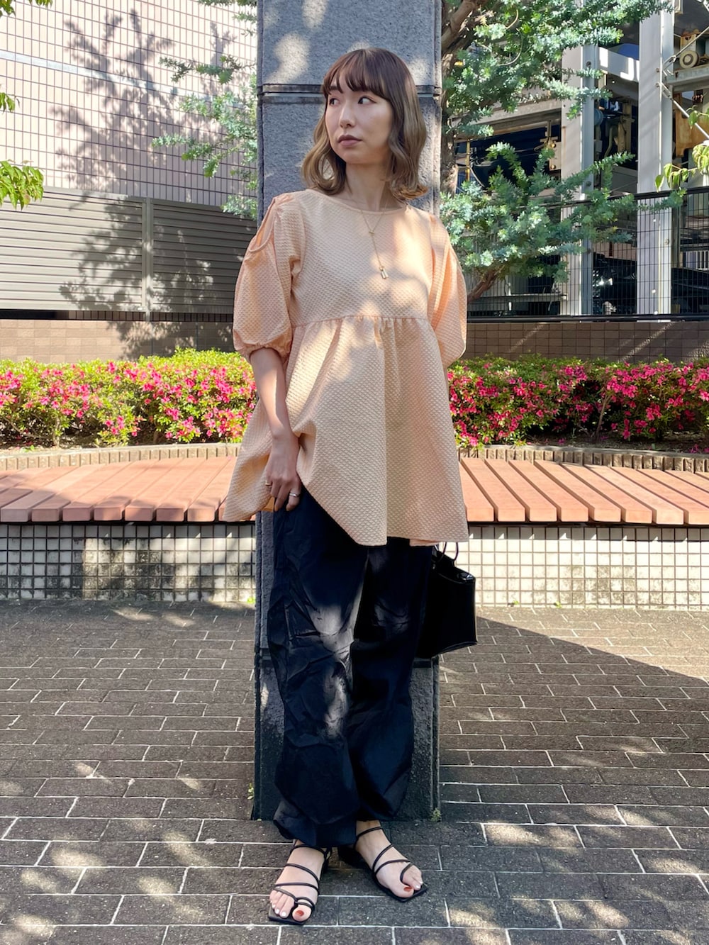 オレンジ系のシャツ/ブラウス、ブラック系のその他パンツ、ブラック系のサンダルを着用したレディースの夏コーディネートの2枚目の写真