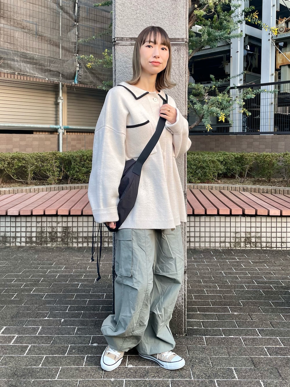 グリーン系のカーゴパンツ、ホワイト系のカーディガン/ボレロ、ベージュ系のスニーカーを着用したレディースの春コーディネートの2枚目の写真