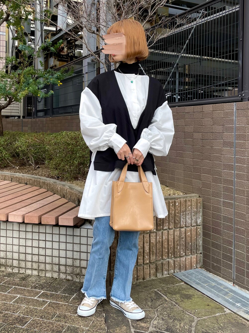 グリーン系のトレンチコート、ブルー系のデニムパンツ、ベージュ系のショルダーバッグを着用したレディースの春コーディネートの2枚目の写真