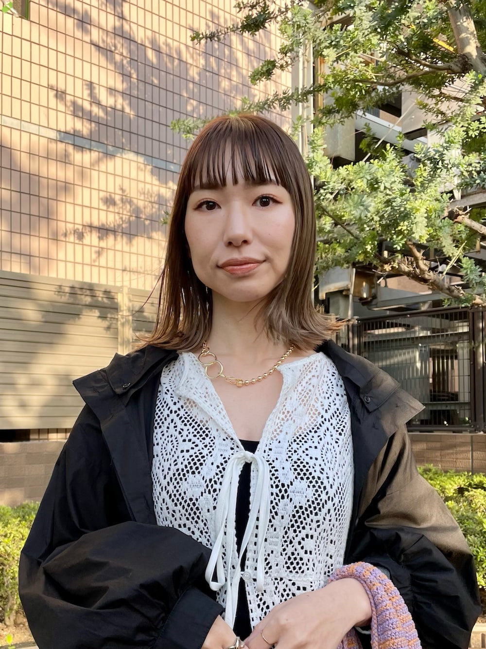 ホワイト系のワンピース、ブラック系のその他パンツ、ブラック系のマウンテンパーカーを着用したレディースの春コーディネートの2枚目の写真