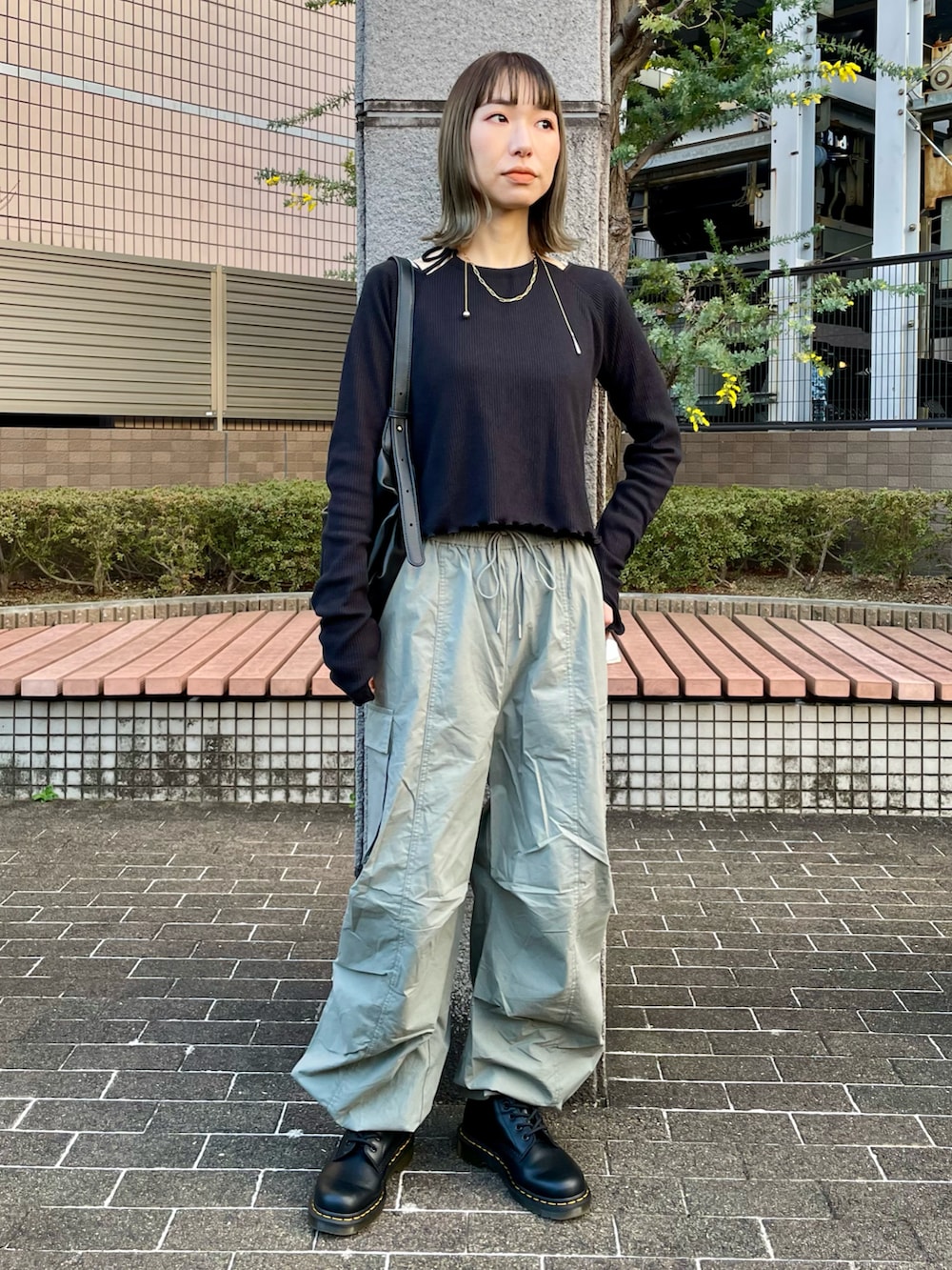 ブラック系のTシャツ/カットソー、ホワイト系のステンカラーコート、グリーン系のカーゴパンツを着用したレディースの冬コーディネートの2枚目の写真