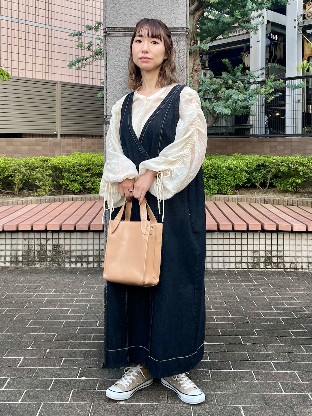 ブラック系のワンピース、ホワイト系のシャツ/ブラウス、ベージュ系のスニーカーを着用したレディースの春コーディネートの2枚目の写真