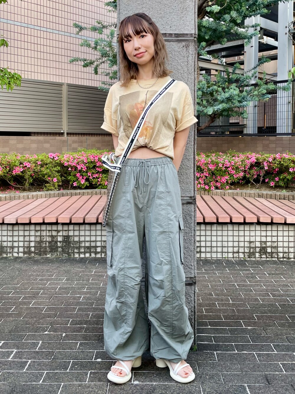 イエロー系のTシャツ/カットソー、グリーン系のカーゴパンツ、ホワイト系のサンダルを着用したレディースの春コーディネートの2枚目の写真